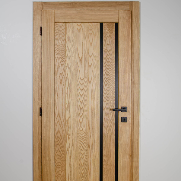 Moderný detail v podobe vsadených kovových prvkov modernizuje klasické drevené dvere